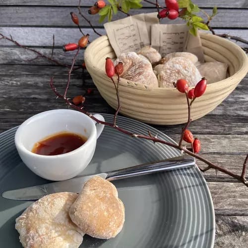 Ciabattini mit Hagebuttenmarmelade  auf grauem Teller angerichtet.